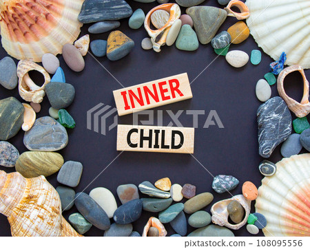 Inner child symbol. Concept words Inner child on beautiful wooden block. Beautiful black table black background. Sea stone sea shell. Psychological, motivational inner child concept. Copy space. 108095556