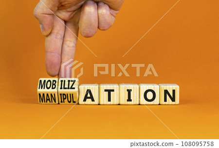 Mobilization or manipulation symbol. Concept words Mobilization Manipulation on wooden cubes. Beautiful orange background. Psychologist hand. Psychology mobilization manipulation concept. Copy space. 108095758