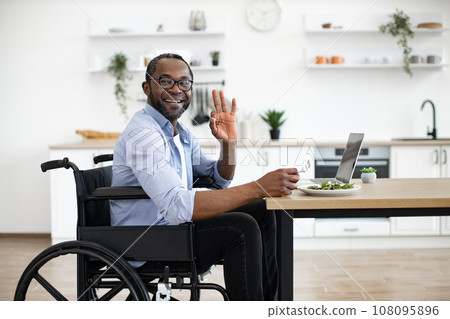 Manager with disability enjoying food in home workplace 108095896