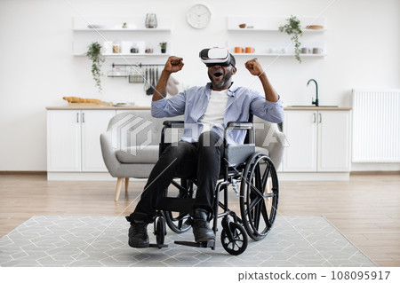 Smiling mature person with disability wearing VR headset and gesturing. Smiling mature person with disability wearing VR headset and gesturing. 108095917
