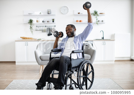 Man with limited mobility lifting weights at home workout 108095995
