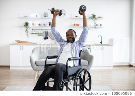 Person with disability working out with dumbbell at home Person with disability working out with dumbbell at home 108095996