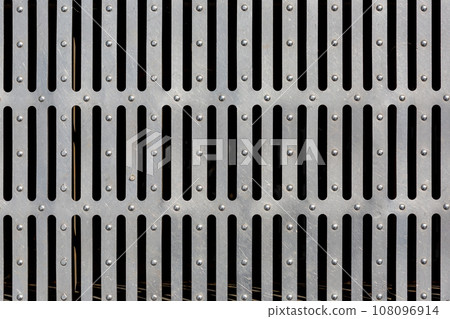 iron drainage grate with stripes, industrial object design, close-up surface texture. 108096914
