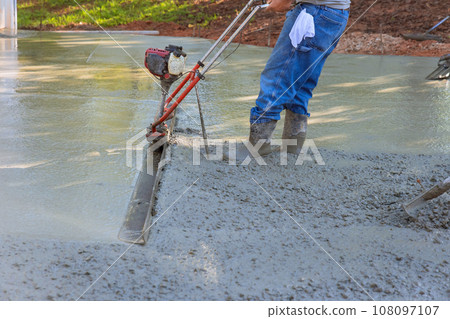 Fresh concrete driveway alignment using tamping machine for new driveway Fresh concrete driveway alignment using tamping machine for new driveway 108097107