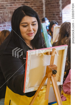Woman with brush painting on canvas 108097494