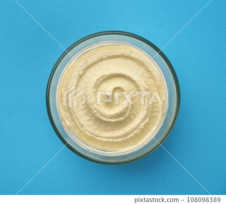 Sweet cottage cheese swirl, bowl of cream cheese with vanilla flavor on blue background, top view Sweet cottage cheese swirl, bowl of cream cheese with vanilla flavor on blue background, top view 108098389