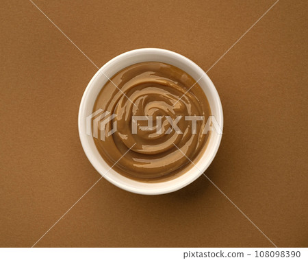 Boiled condensed milk, bowl of melted caramel cream, top view 108098390