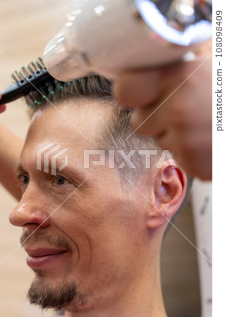 professional hairdresser cuts a man's hair. visit to the barber shop 108098409