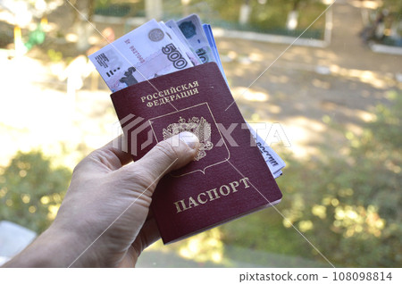 passport of a Russian citizen with invested rubles in a man's hand 108098814