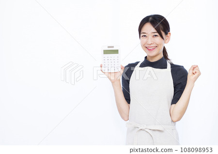 A housewife in her 30s holding a calculator and doing a fist pump 108098953