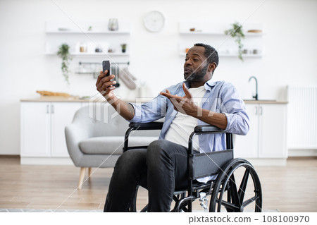 Person with disability chatting via video call at home. 108100970