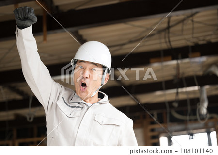 A site supervisor working at a construction site, looking at the camera and shouting with a fist pump, copy space on the right A site supervisor working at a construction site, looking at the camera and shouting with a fist pump, copy space on the right 108101140