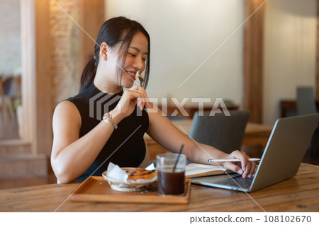 Gorgeous Asian woman is having breakfast while working remotely at a coffee shop. Lifestyle concept 108102670