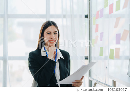 Beautiful young teen asian businesswoman using note pad thinking with planning working on financial document, tax, exchange, accounting and Financial advisor. 108103037