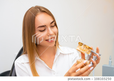 Dentist student holding a model jaw for study stomatology. 108103250