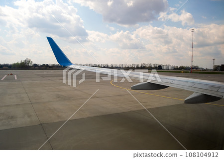 View of jet airplane wing taxiing runway after landing at airport. Travel and air transportation concept. View of jet airplane wing taxiing runway after landing at airport. Travel and air transportation concept. 108104912