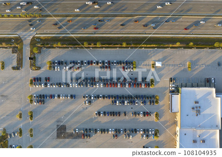 View from above of dealers outdoor parking lot with many brand new cars in stock for sale on highway side. Concept of development of american automotive industry 108104935