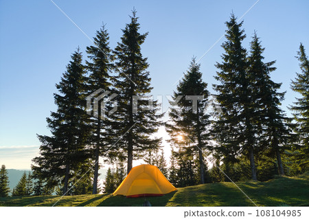 Tourist camping tent on mountain campsite at bright sunny evening. Active tourism and hiking concept Tourist camping tent on mountain campsite at bright sunny evening. Active tourism and hiking concept 108104985