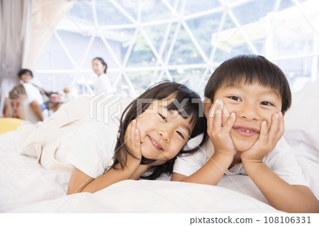 Children frolicking in a dome tent at a glamping facility Children frolicking in a dome tent at a glamping facility 108106331