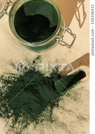 Organic blue-green algae spirulina powder food in glass jar with wooden spoon. Health benefits of spirulina chlorella. Dietary supplement superfood 108106432