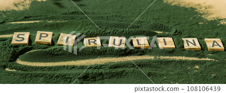 Wooden blocks with text SPIRULINA chlorella on background of algae superfood powder. Healthy benefits supplement and vegan antioxidant healthy eating Wooden blocks with text SPIRULINA chlorella on background of algae superfood powder. Healthy benefits supplement and vegan antioxidant healthy eating 108106439