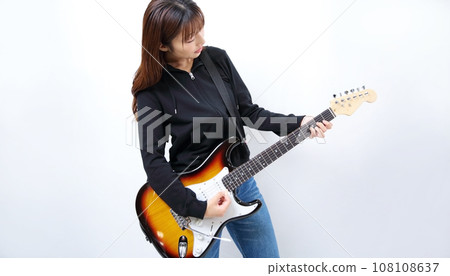Image of a woman playing an electric guitar Image of a woman playing an electric guitar 108108637