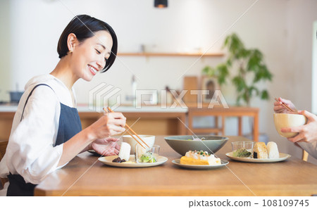woman eating with family 108109745