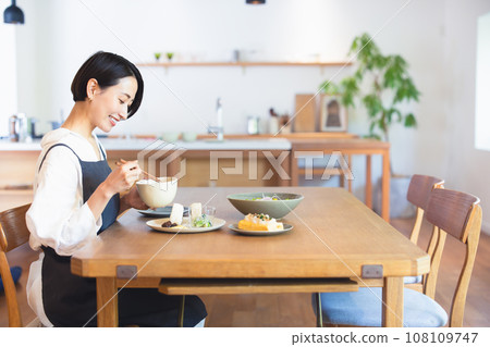 woman eating breakfast alone woman eating breakfast alone 108109747