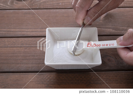 1 teaspoon salt with a measuring spoon 1 teaspoon salt with a measuring spoon 108110036