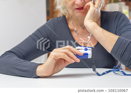 Woman thoughtfully looks at the results of measuring the heart pulse . Woman thoughtfully looks at the results of measuring the heart pulse . 108110067