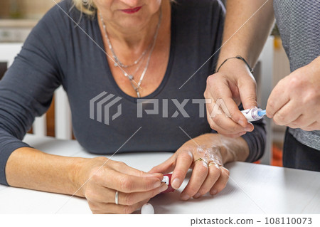 Male hands prepare blood lamcets for woman 108110073