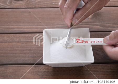 1/2 teaspoon salt with a measuring spoon 108110306
