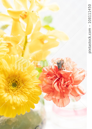 An elderly couple cuddling with miniature dolls and flowers 108111450