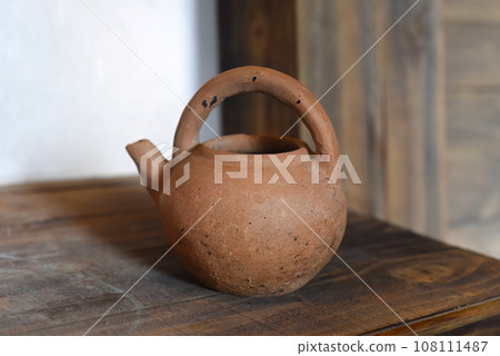 Clay teapot on a wooden table 108111487