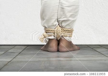The man's legs are tied by rope 108111933