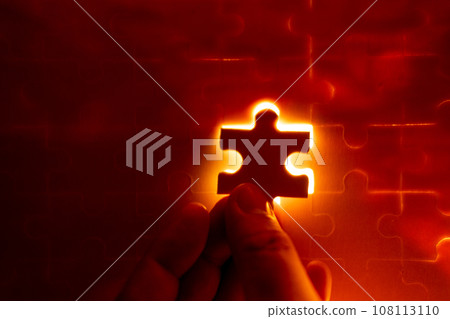 Pieces of a jigsaw puzzle filled with orange lights by hand Success concept Pieces of a jigsaw puzzle filled with orange lights by hand Success concept 108113110