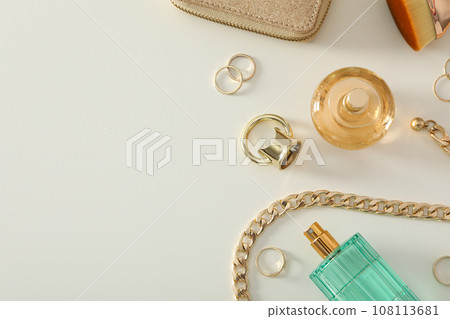 A bottle of perfume on a table with gold ornaments A bottle of perfume on a table with gold ornaments 108113681