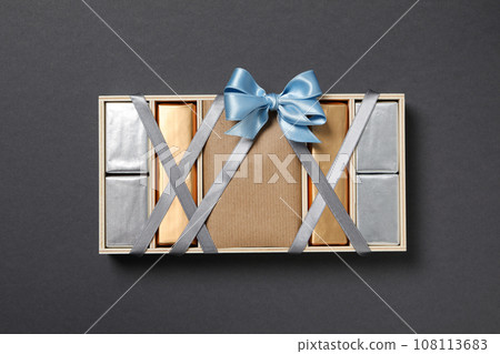 Chocolates in box with ribbon on gray background, top view Chocolates in box with ribbon on gray background, top view 108113683