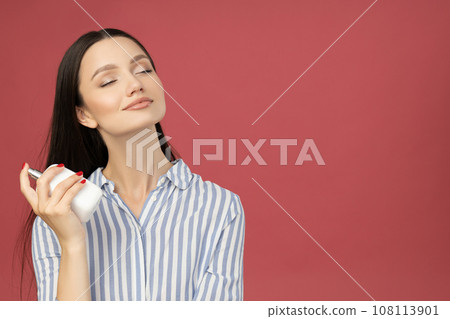Attractive girl in a shirt with perfume in her hand 108113901