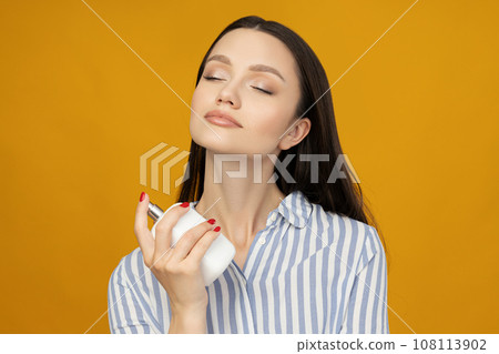 Attractive girl in a shirt with perfume in her hand 108113902
