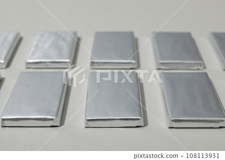 Chocolates in silver foil on gray background, close up 108113931