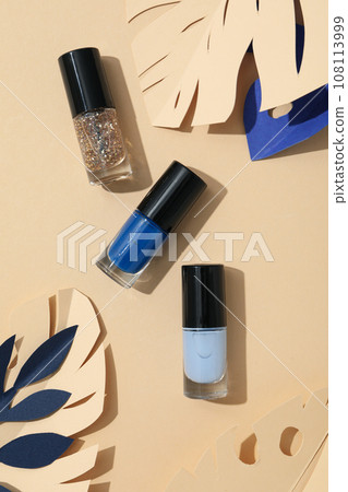 Multicolored nail polishes with decorative paper leaves 108113999