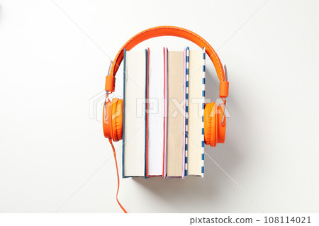 Headphones on books on white background, top view 108114021
