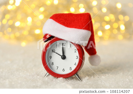 A clock with a Santa hat with a New Year's decoration. 108114207