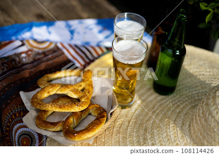 Celebration Of The Famous German Beer Festival Oktoberfest. Original Bavarian Oktoberfest Pretzels In A Basket With Beer From Germany On Wooden Board. Celebration Of The Famous German Beer Festival Oktoberfest. Original Bavarian Oktoberfest Pretzels In A Basket With Beer From Germany On Wooden Board. 108114426