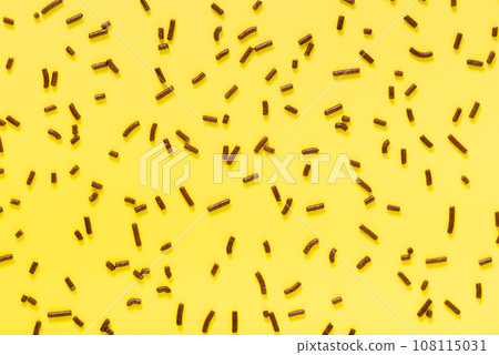 flat lay of chocolate sprinkles over yellow  108115031