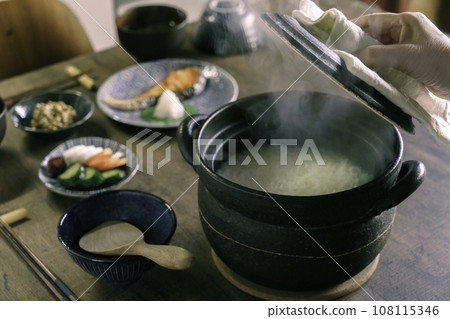 Breakfast: White rice steaming from a clay pot 108115346