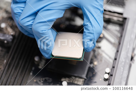Handyman in rubber gloves installing computer processor closeup Handyman in rubber gloves installing computer processor closeup 108116648