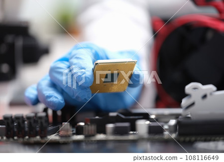 Repairman installing computer processor into motherboard closeup 108116649