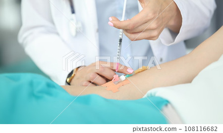 Doctors hands place dropper in patients hand 108116682